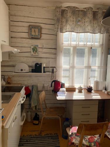 a kitchen with a counter and a table and a window at Jõevaara Veskitalu in Pääsna