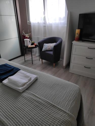 a bedroom with a bed and a chair and a television at Kastell-Mor 2 chambre d'hôtes à Santec in Santec