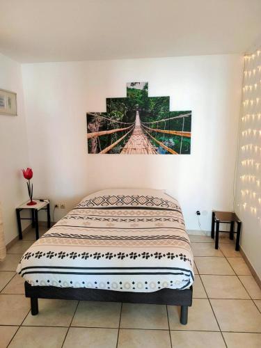une chambre avec un lit et un tableau au mur dans l'établissement Le 109 : Calme, terrasse, garage et confort en pleine ville, à Montpellier