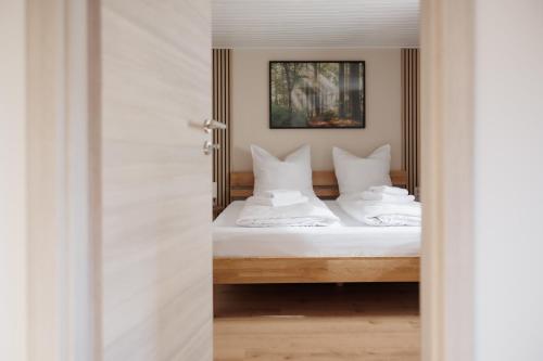 a bedroom with a bed with white sheets and pillows at CASA BENJI - Familienfreundliche FeWo - Landhausstil - Garten - Parkplatz in Pirna