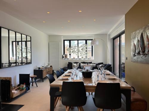 une grande salle à manger avec une longue table et des chaises dans l'établissement Les Tamaris - Grande Maison de Plage - Jacuzzi, à Carolles