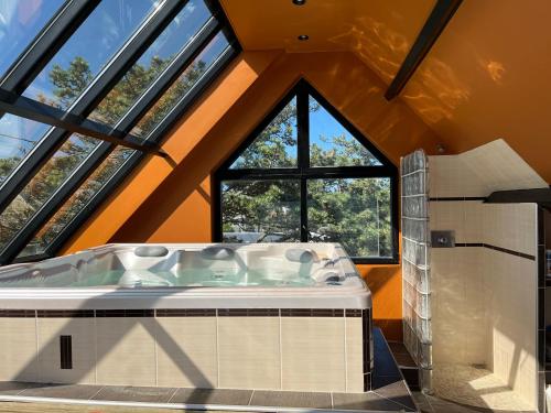 Cette chambre dispose d'une grande baignoire et de fenêtres. dans l'établissement Les Tamaris - Grande Maison de Plage - Jacuzzi, à Carolles