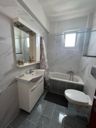 a bathroom with a sink and a tub and a toilet at King George in Korinos