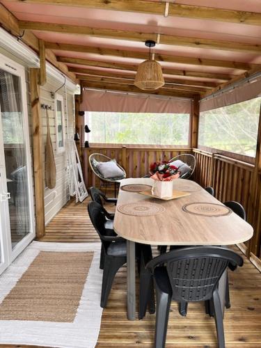 une terrasse couverte avec une table et des chaises sur une maison dans l'établissement Mobil Home, à Mimizan-Plage