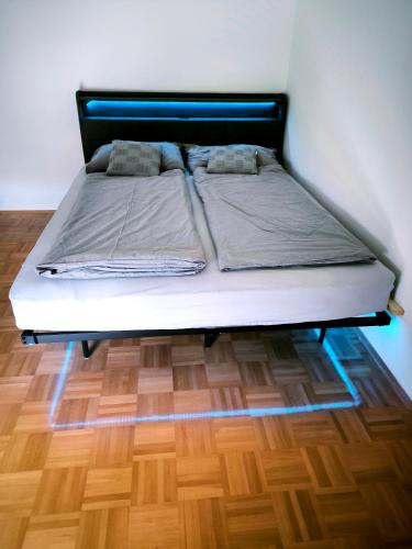 a bed in a room with a wooden floor at Garden Apartment Pejić - near Bovec, Soča Valley in Bovec