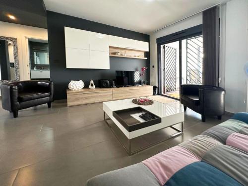 un soggiorno con un divano e un tavolino da caffè di Oasis Beach nice ground floor bungalow overlooking the pool and garden a Playa Flamenca