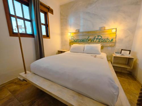 a large white bed in a room with a window at 40 Cañones in Mahahual