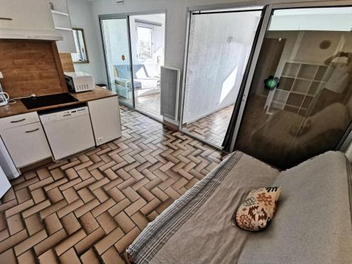 un salon avec un canapé et une cuisine dans l'établissement Résidence LES CYCLADES - 2 Pièces pour 6 Personnes 94, à Port-Leucate