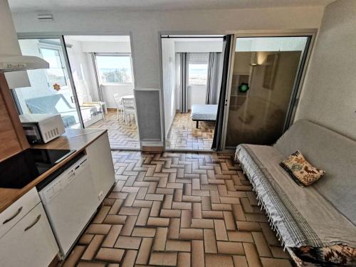 une cuisine et un salon avec un canapé dans une pièce dans l'établissement Résidence LES CYCLADES - 2 Pièces pour 6 Personnes 94, à Port-Leucate