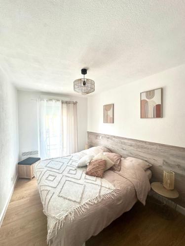 una camera da letto con un letto grande e un lampadario di Appartement a Port-Saint-Louis-du-Rhône