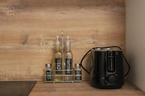 Una cafetera y dos botellas de alcohol junto a una tostadora en NiDalia Apartment in Graz, en Graz