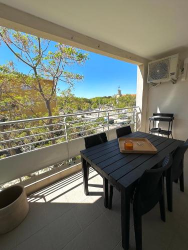 une table et des chaises sur un balcon avec vue dans l'établissement Appartement, à Port-Saint-Louis-du-Rhône