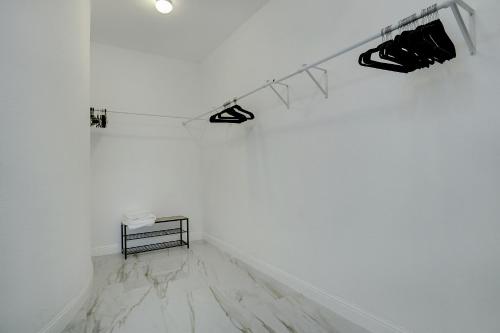 a white room with a table and a white wall at GORGEOUS 5-bd 4ba w Pool, Hot Tub, 2 kitchens, & Game Room Near Dallas Airports! in Irving