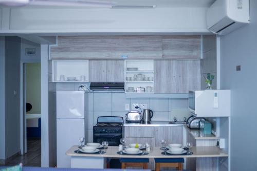 a kitchen with wooden cabinets and a counter top at Durban Beachfront Bliss in Durban
