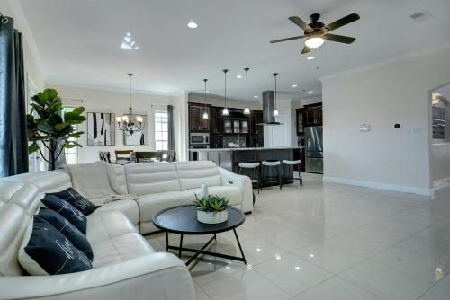 a living room with a white couch and a table at GORGEOUS 5-bd 4ba w Pool, Hot Tub, 2 kitchens, & Game Room Near Dallas Airports! in Irving