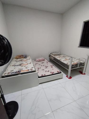 two beds sitting in a room with a room with two at La Fortaleza Marapanim in Marapanim