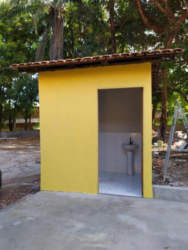 a small yellow building with a toilet in it at La Fortaleza Marapanim in Marapanim