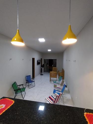 a living room with colorful chairs and lights at La Fortaleza Marapanim in Marapanim