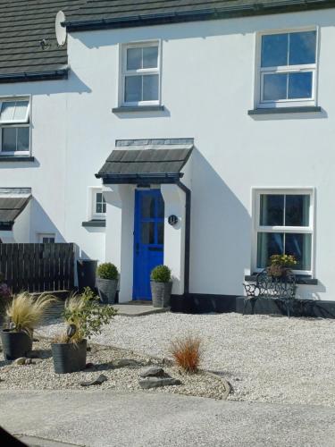 una casa bianca con una porta blu di Corby house & cabin a Ardara