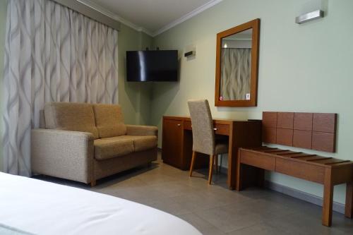 a hotel room with a desk and a chair and a mirror at Nou Avenida in Gata de Gorgos