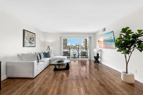 een woonkamer met een witte bank en een tafel bij Sunlit Marina View 2BR - Blue Agate Seaside Gem in Los Angeles