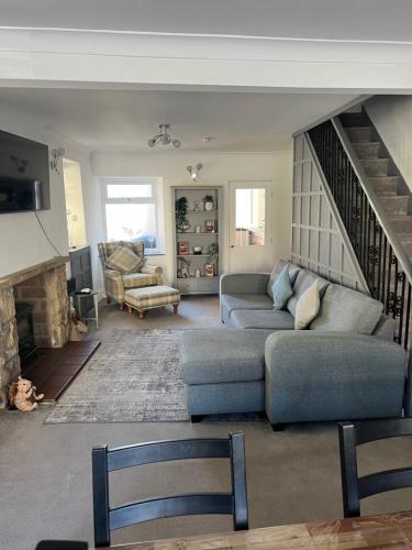 een woonkamer met een bank en een open haard bij Epworth Cottage in Crich