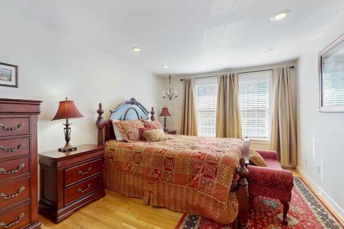 a bedroom with a bed and a dresser and windows at Casa Esmeralda in Lakewood