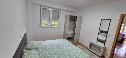 une chambre avec un lit, un miroir et une télévision dans l'établissement Apartment IN Ohrid, à Ohrid