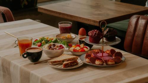 a table with plates of food and drinks on it at Hotel Heye 130 in Amsterdam