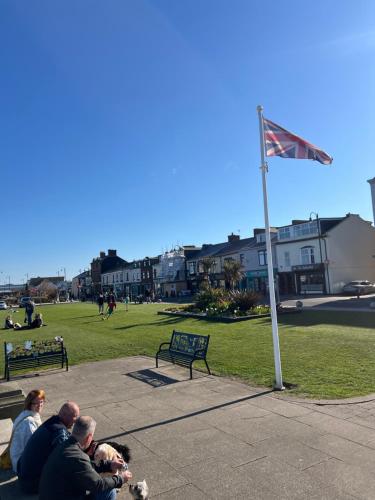 a group of people sitting in a park with a flag at Lovely place in Seaham GO69OOD in Seaham