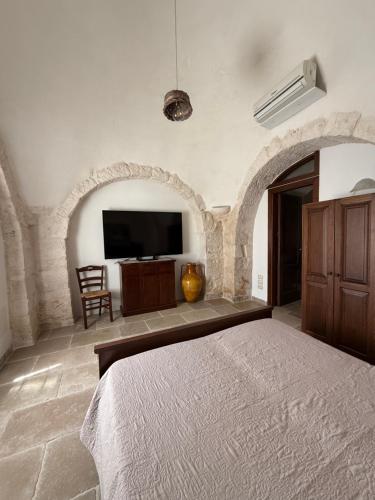 a bedroom with a bed and a flat screen tv at B&B Masseria Nardelli in Locorotondo