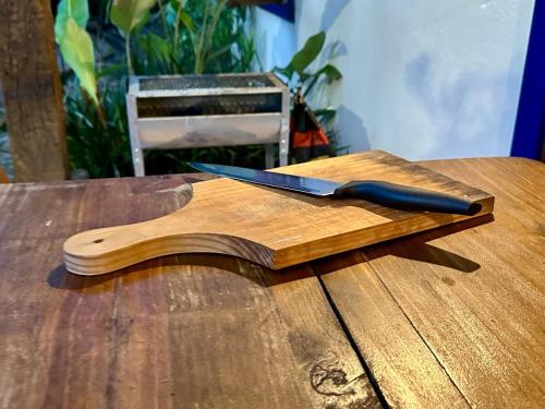a knife on a wooden cutting board on a table at Casa Rústica - 3 vagas de garagem - Pet Friendly com vista para Serra de São José in Tiradentes