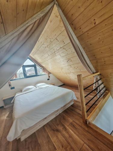 a bedroom with a bed and a wooden ceiling at La Livada Chalet in Vişeu de Sus