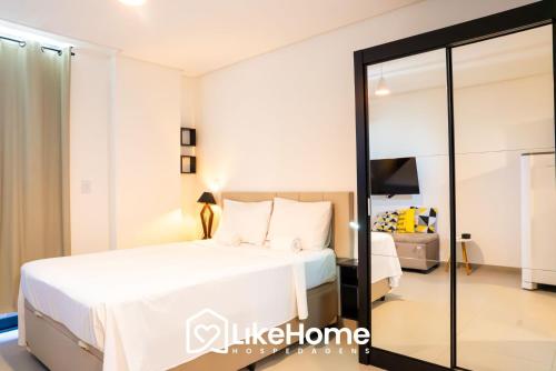 a bedroom with a large white bed and a mirror at Vivir Maria Paula - Intermares in Cabedelo
