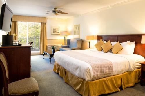 a hotel room with a bed and a chair at Inn on the Lake in Fall River