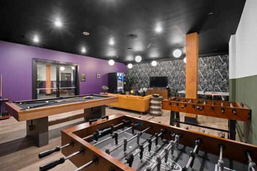 a billiards room with purple walls and ping pong tables at 888 Baronne in New Orleans