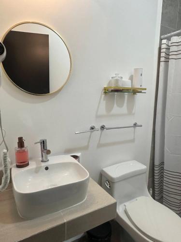 ein Badezimmer mit Waschbecken, Toilette und Spiegel in der Unterkunft Casa Khira in Playa del Carmen