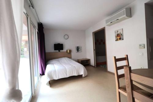a bedroom with a bed and a table and a window at Résidence Balcon Du Canigou - Joli studio dans la résidence Les Balcons du Canigou MAE-5381 in Vernet-les-Bains