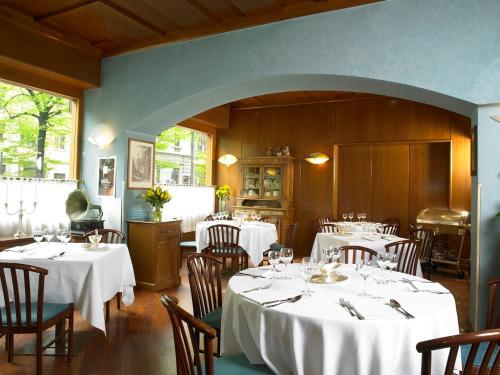 a dining room with tables and chairs with white tablecloths at Hotel Europa in Padova