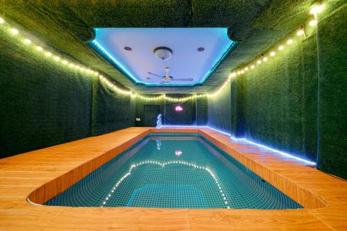 an indoor swimming pool with lights on the ceiling at Bigg Villa at Walking Street in Pattaya South