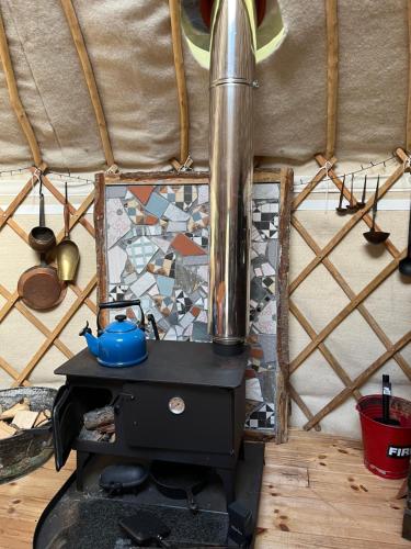 a stove with a tea pot on top of it at Magical Quirky Romantic Yurt in Balquhidder in Balquhidder