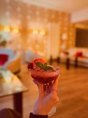 a person holding a piece of food in their hand at Hotel Borowiecki in Łódź