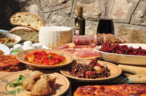 a table with plates of food and bottles of wine at Agriturismo La Dimora dei Cavalieri in Vaglio di Basilicata
