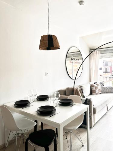 une salle à manger blanche avec une table et des chaises blanches dans l'établissement Appartement 2 min de la plage - 5 personnes - P2 et Cabine, au Grau-du-Roi