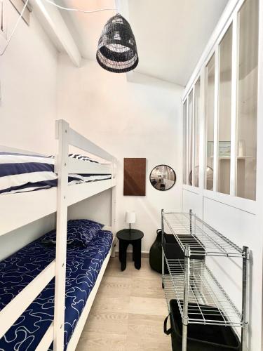 une chambre avec deux lits superposés et une table dans l'établissement Appartement 2 min de la plage - 5 personnes - P2 et Cabine, au Grau-du-Roi