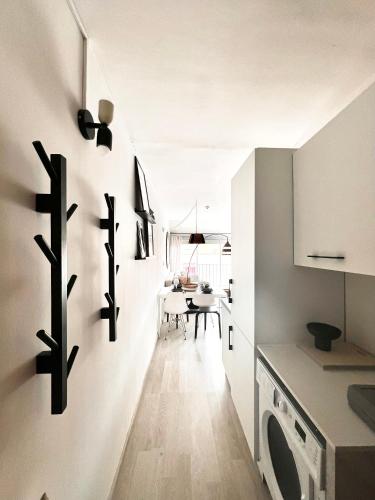 une cuisine avec un lave-linge et un sèche-linge sur le mur dans l'établissement Appartement 2 min de la plage - 5 personnes - P2 et Cabine, au Grau-du-Roi