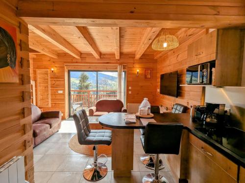 - une cuisine et un salon avec une table dans une cabine dans l'établissement la brume des cimes, à Bussang