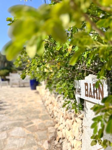 a sign on a stone wall with plants at Ta Skorba Farmhouse Mgarr in Mġarr
