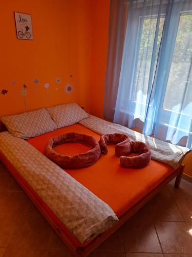 a bed with two large pretzels on top of it at Ózon Apartman Igal in Igal