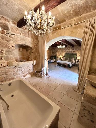 a large bathroom with a tub in a stone wall at Ta Skorba Farmhouse Mgarr in Mġarr